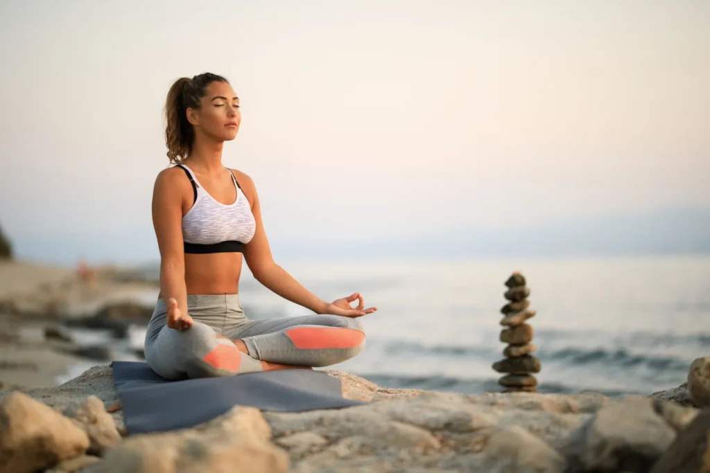 Persona practicando mindfulness en posición de meditación con los ojos cerrados y expresión de calma y atención plena